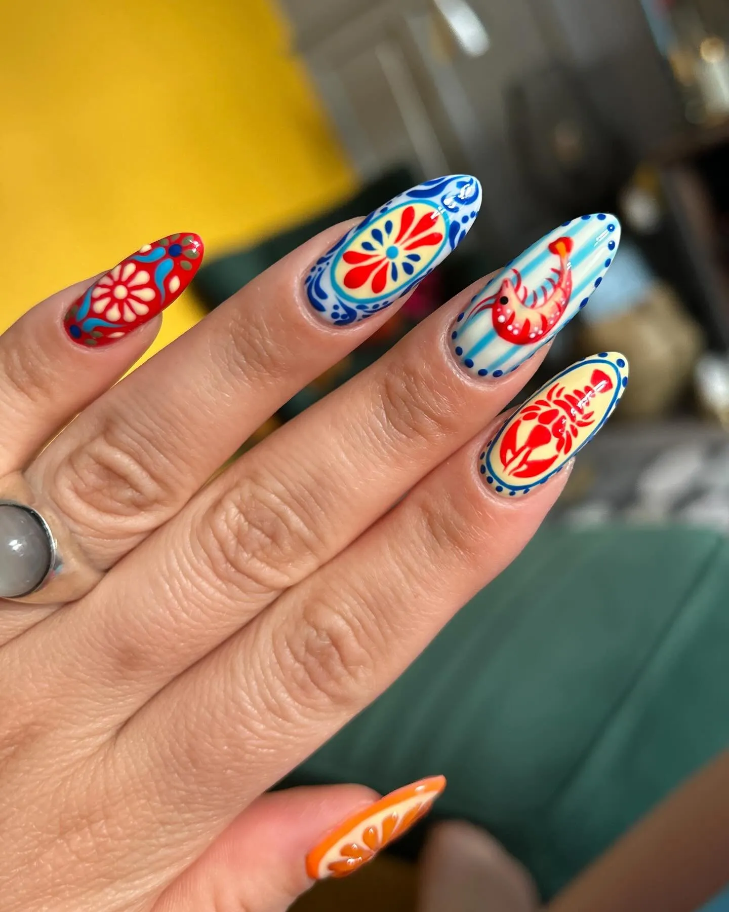 Nail art Destination nails σε νύχια αμυγδαλωτού σχήματος, με μοτίβα μεσογειακής έμπνευσης σε κόκκινο, μπλε και πορτοκαλί