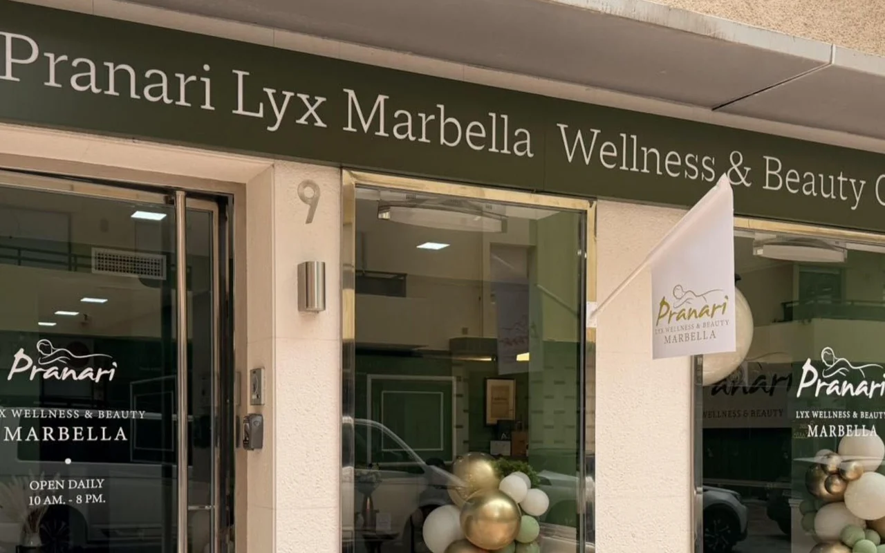 Ο χώρος της Anchan Massage στη Marbella, ένα στούντιο ευεξίας και ομορφιάς με πράσινη πρόσοψη και λευκά-χρυσά μπαλόνια δίπλα στη γυάλινη είσοδο.